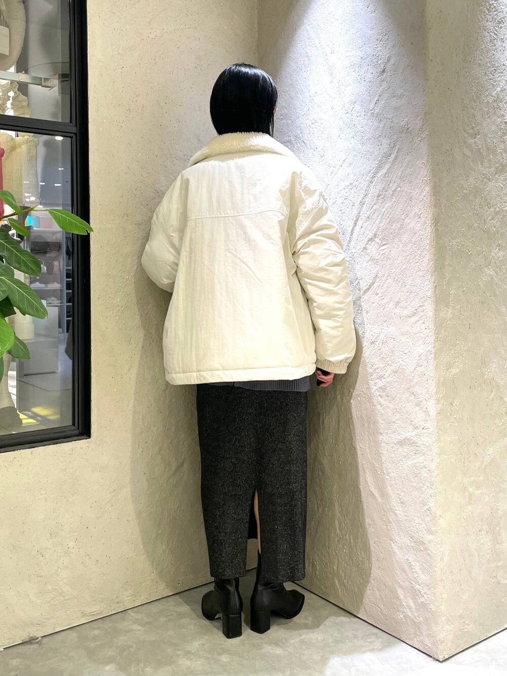 ブラック系のショルダーバッグ、ブルー系のニット/セーター、ブラック系のパンプスを着用したレディースの冬コーディネートの2枚目の写真