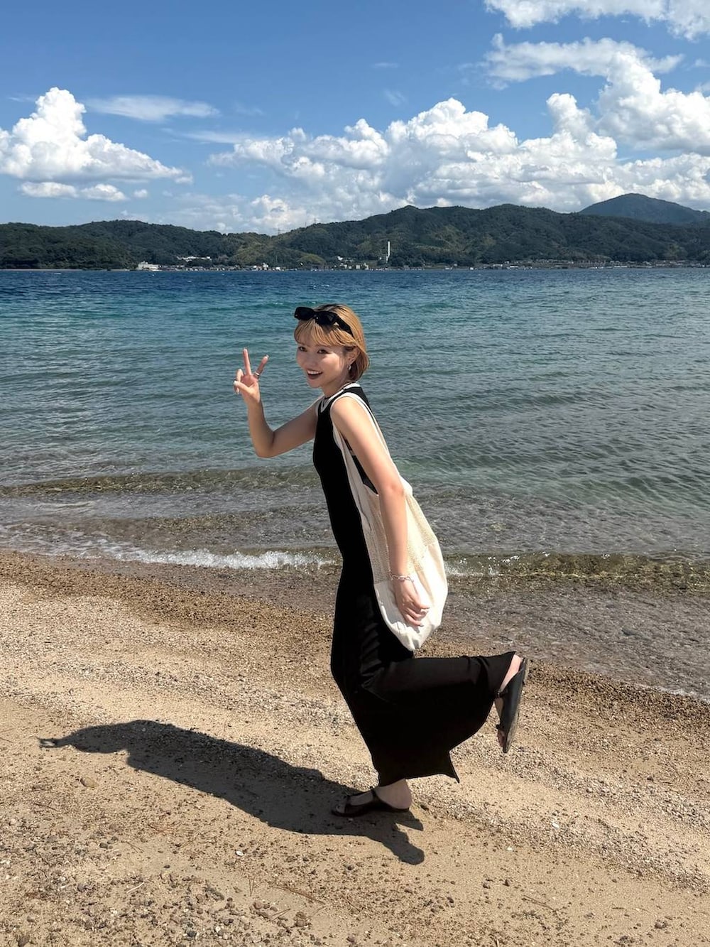 ブラック系のワンピースを着用したレディースの夏コーディネートの2枚目の写真
