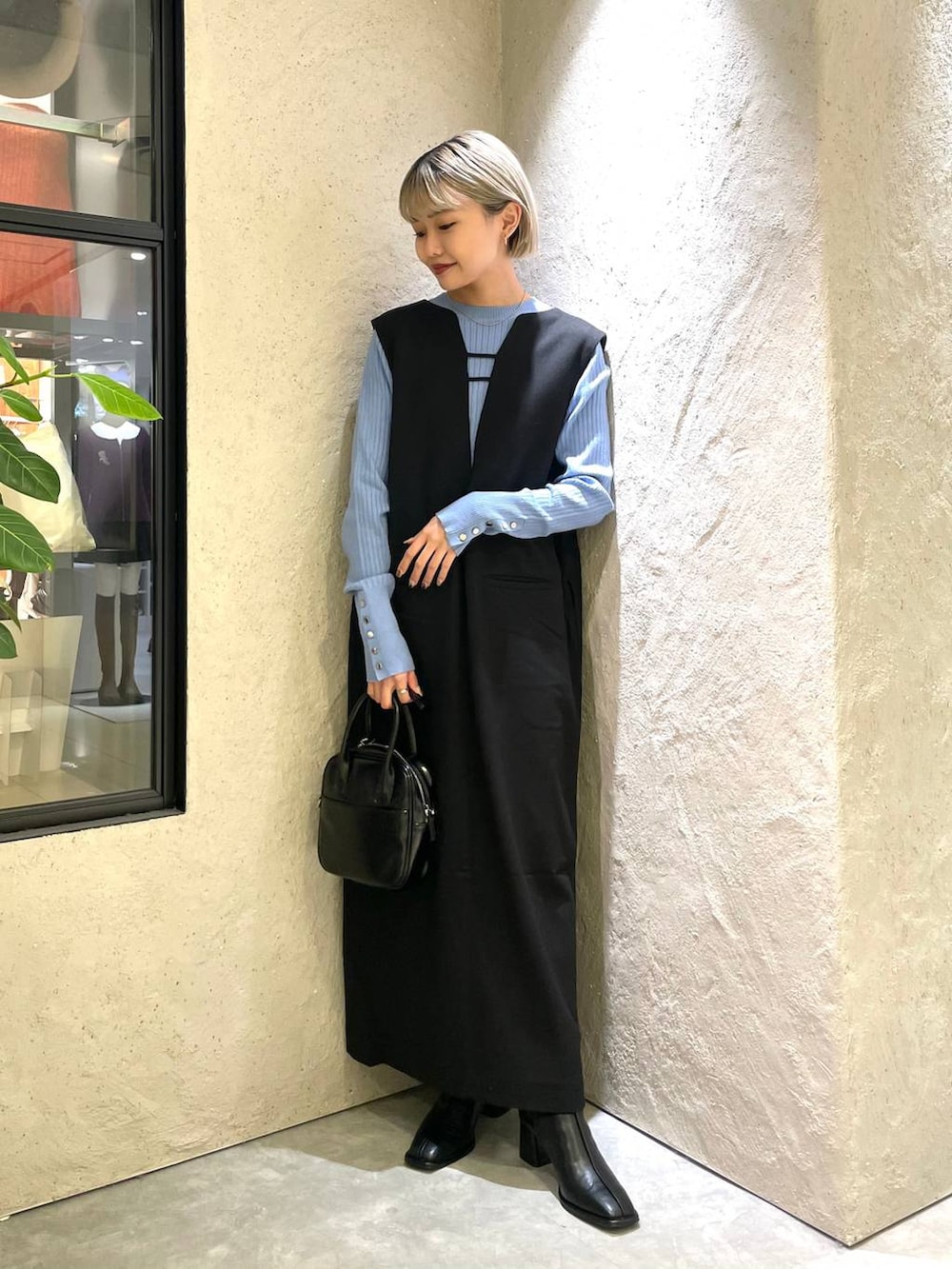 ブラック系のワンピース、ブルー系のニット/セーター、ブラック系のパンプスを着用したレディースの秋コーディネートの4枚目の写真