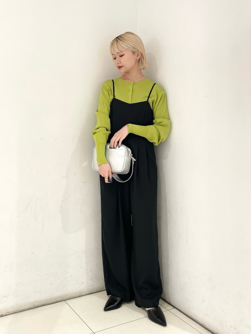 ブラック系のサロペット/オーバーオール、グリーン系のカーディガン/ボレロ、シルバー系のショルダーバッグを着用したレディースの春コーディネートの3枚目の写真