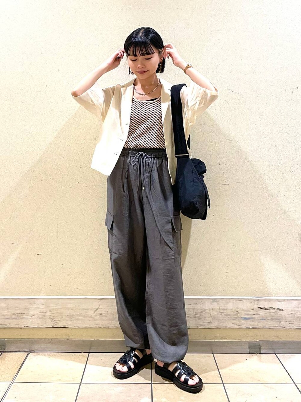 ホワイト系のシャツ/ブラウス、グレー系のカーゴパンツ、ブラック系のスニーカーを着用したレディースの夏コーディネートの4枚目の写真