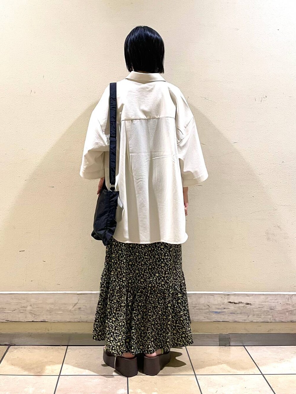 ブラック系のショルダーバッグ、ブラウン系のサンダル、その他のワンピースを着用したレディースの夏コーディネートの2枚目の写真