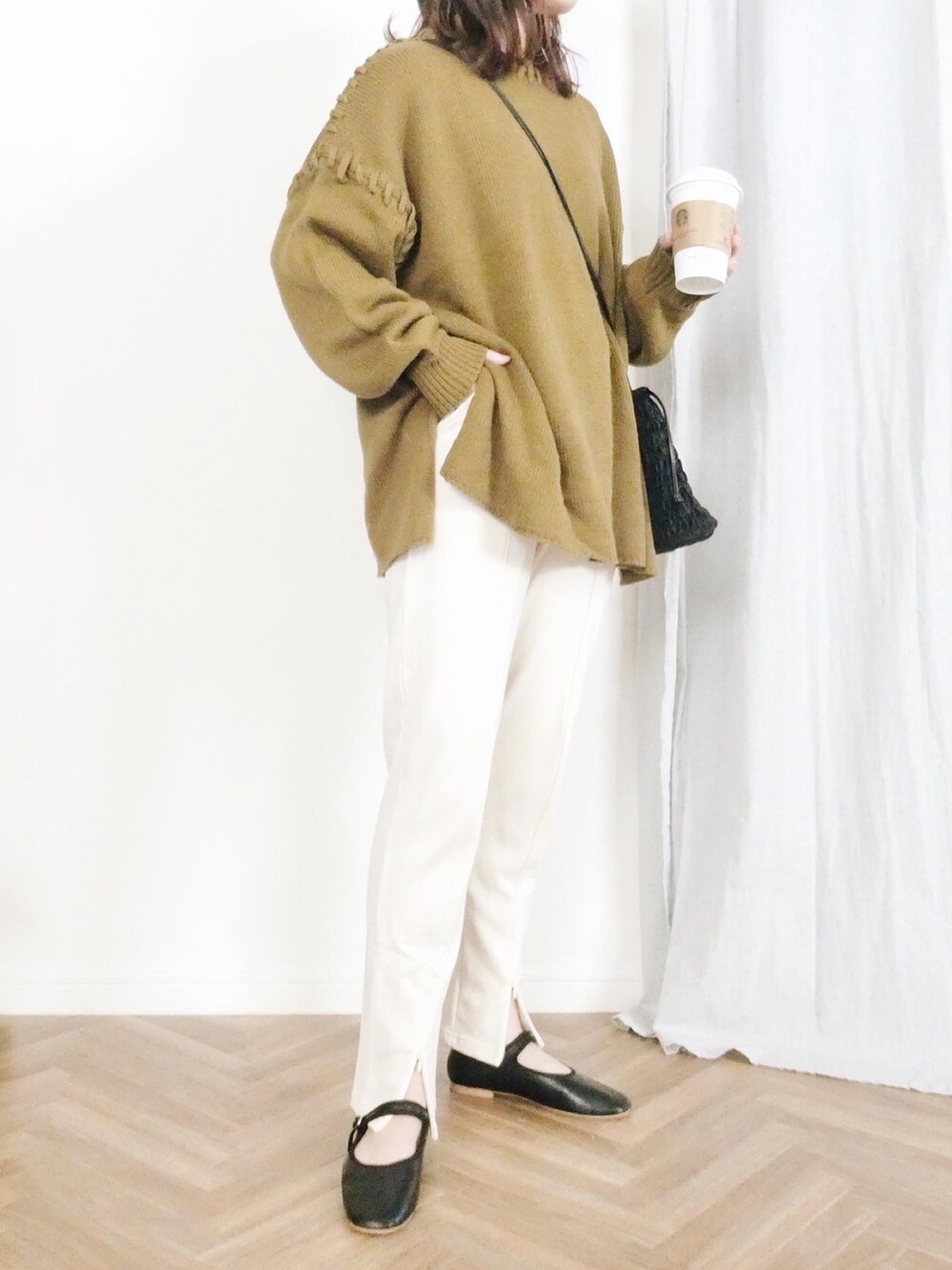 グリーン系のニット/セーター、ホワイト系のスウェットパンツ、ブラック系のショルダーバッグを着用したレディースの冬コーディネートの2枚目の写真