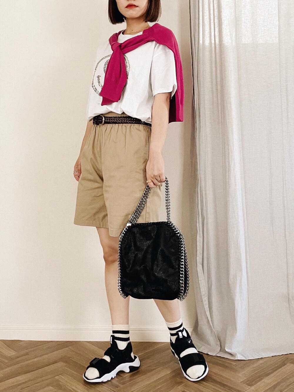 ホワイト系のTシャツ/カットソー、ブラック系のサンダル、ブラック系のショルダーバッグを着用したレディースの夏コーディネートの3枚目の写真