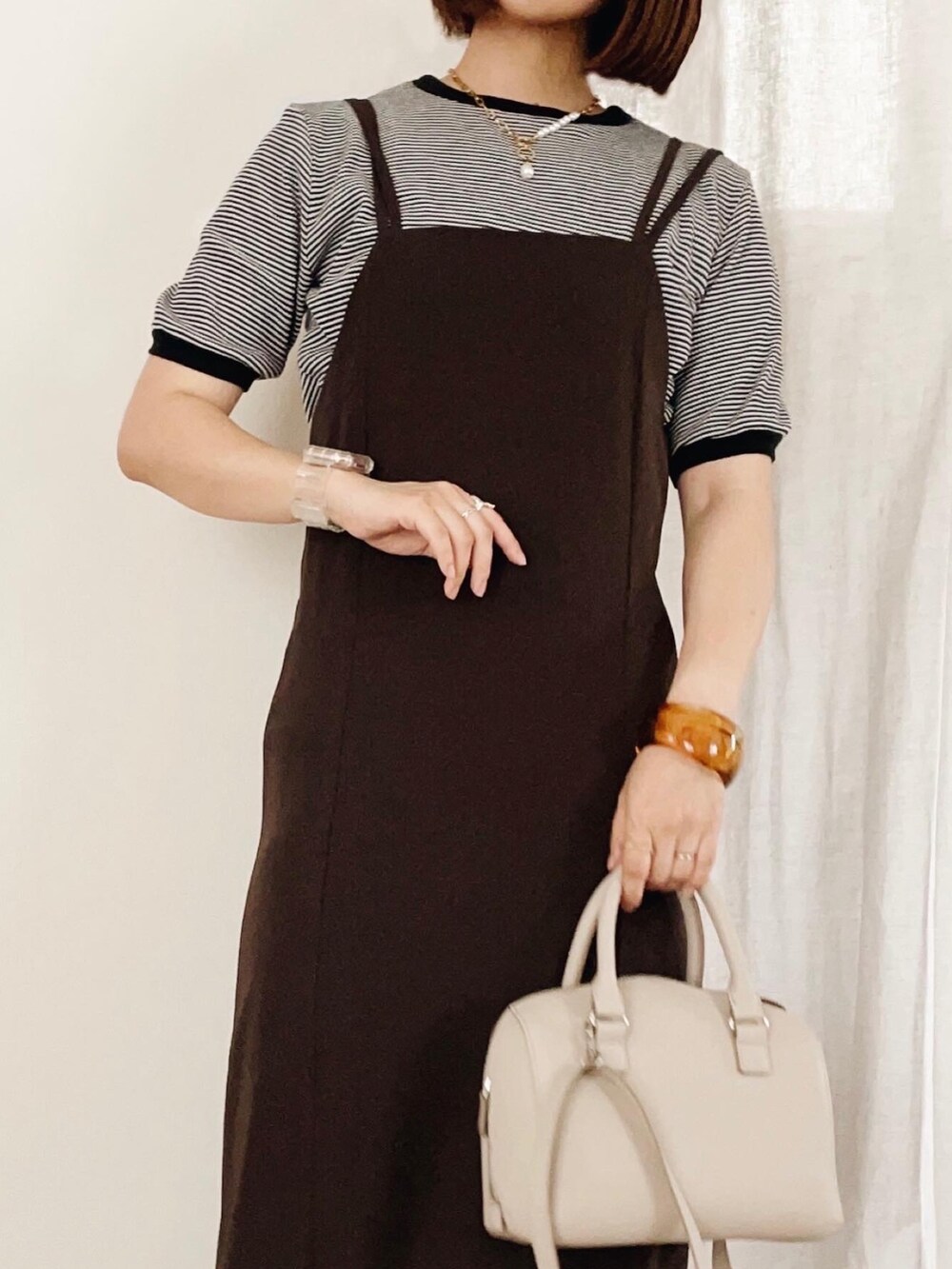 ブラウン系のワンピース、ブラック系のTシャツ/カットソーを着用したレディースの夏コーディネートの2枚目の写真