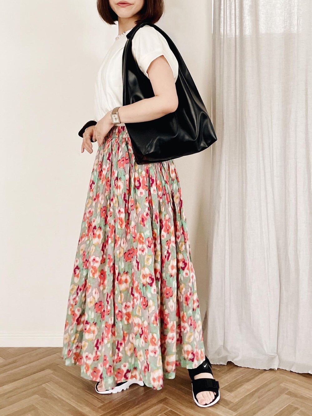 ホワイト系のTシャツ/カットソー、レッド系のスカート、ブラック系のトートバッグを着用したレディースの夏コーディネートの2枚目の写真