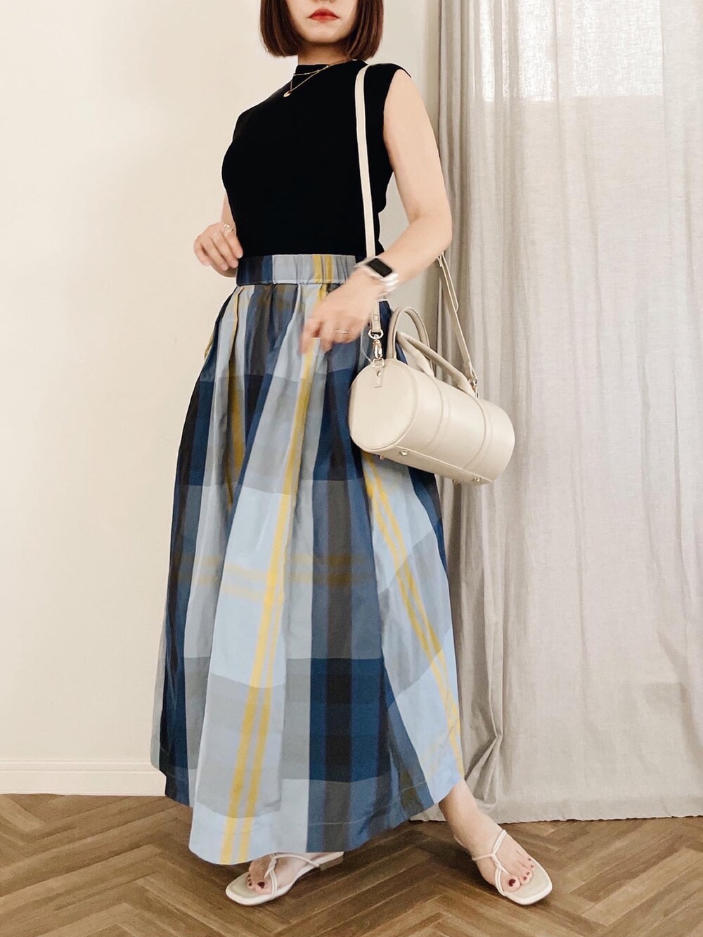 ブラック系のニット/セーター、ホワイト系のショルダーバッグ、ホワイト系のサンダルを着用したレディースの夏コーディネートの2枚目の写真