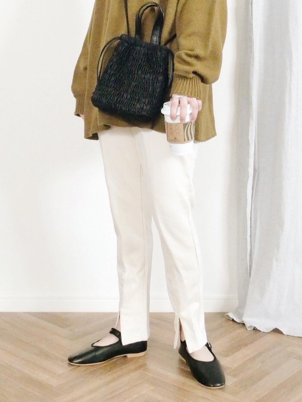 グリーン系のニット/セーター、ホワイト系のスウェットパンツ、ブラック系のショルダーバッグを着用したレディースの冬コーディネートの3枚目の写真