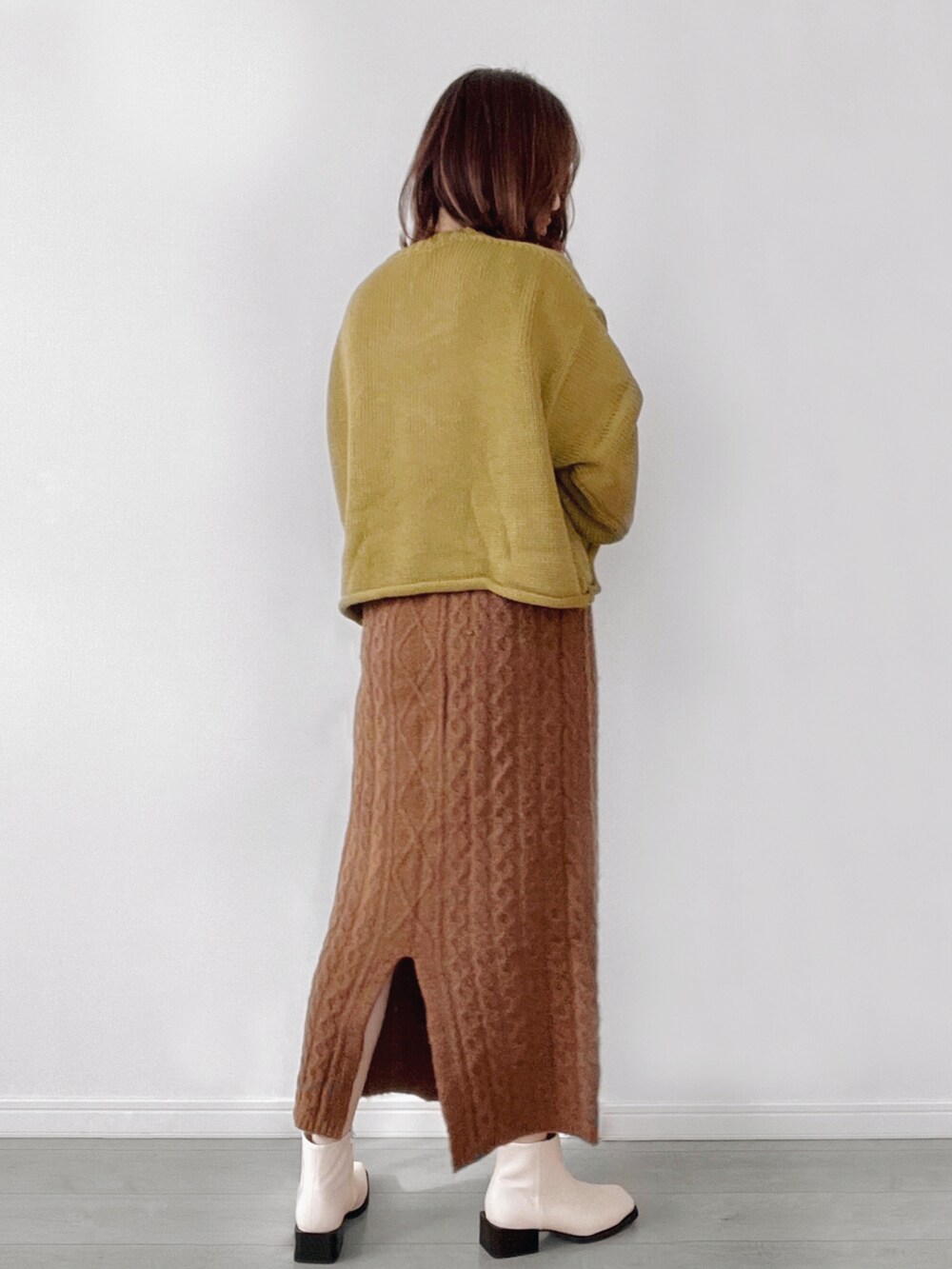 グリーン系のニット/セーター、ホワイト系のショルダーバッグを着用したレディースの秋コーディネートの2枚目の写真