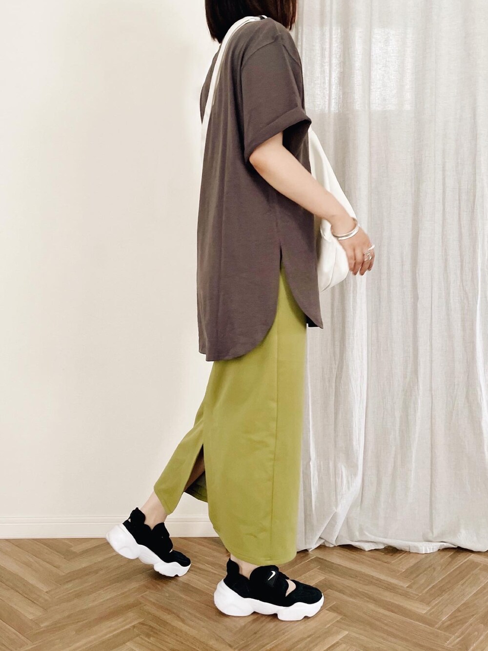 ブラック系のスニーカー、グリーン系のスカート、グレー系のTシャツ/カットソーを着用したレディースの夏コーディネートの2枚目の写真