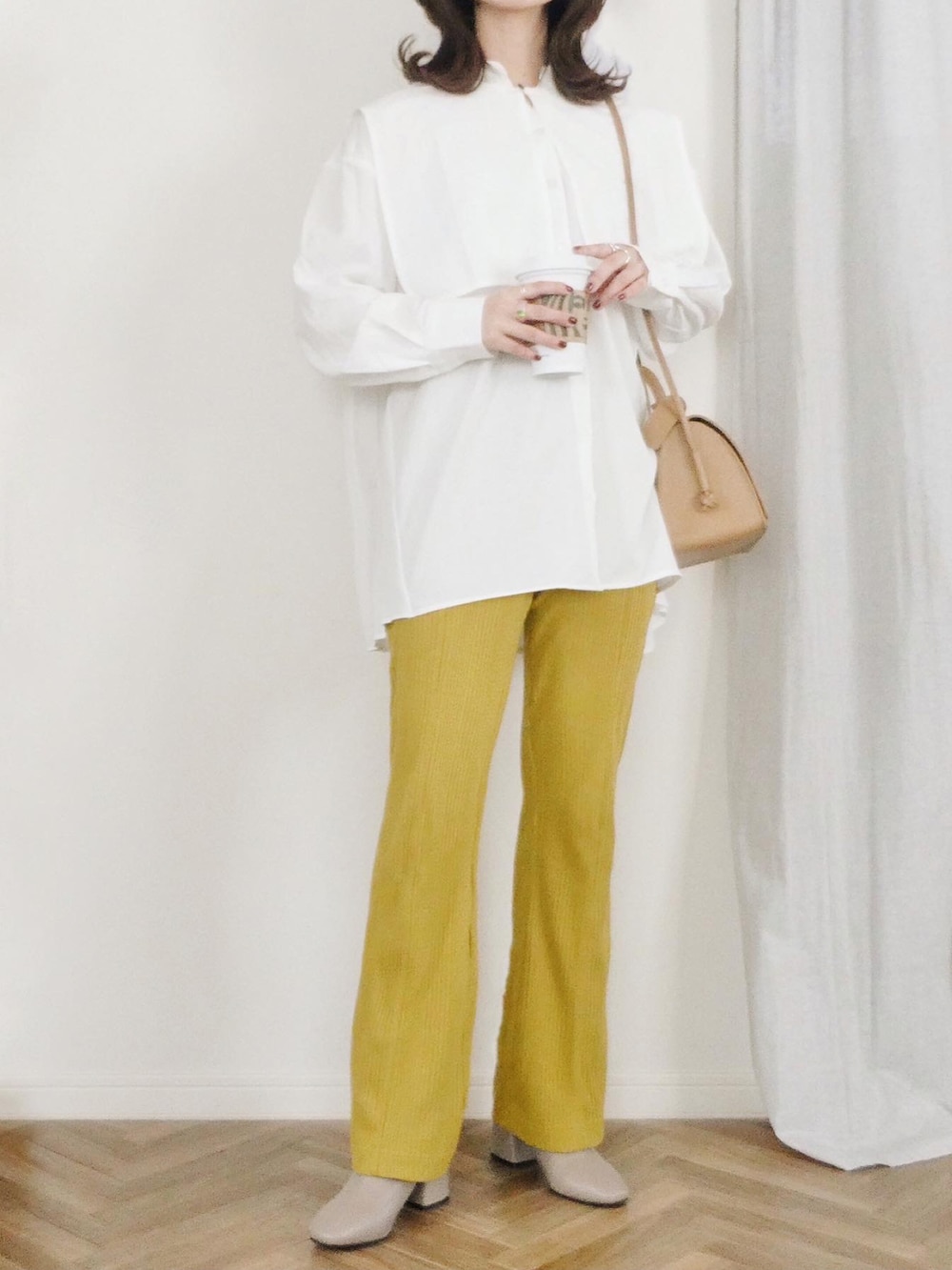 ホワイト系のシャツ/ブラウス、ブラウン系のブルゾン、ベージュ系のショルダーバッグを着用したレディースの冬コーディネートの2枚目の写真