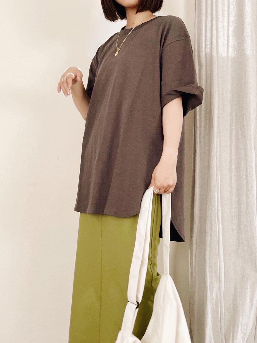 ブラック系のスニーカー、グリーン系のスカート、グレー系のTシャツ/カットソーを着用したレディースの夏コーディネートの3枚目の写真