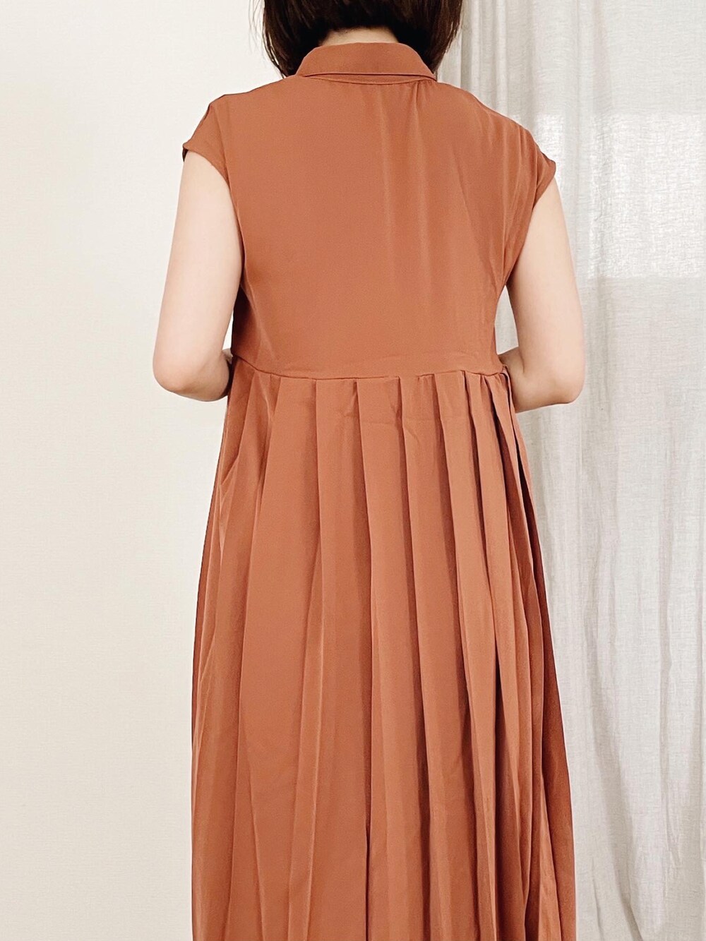 オレンジ系のワンピースを着用したレディースの夏コーディネートの2枚目の写真