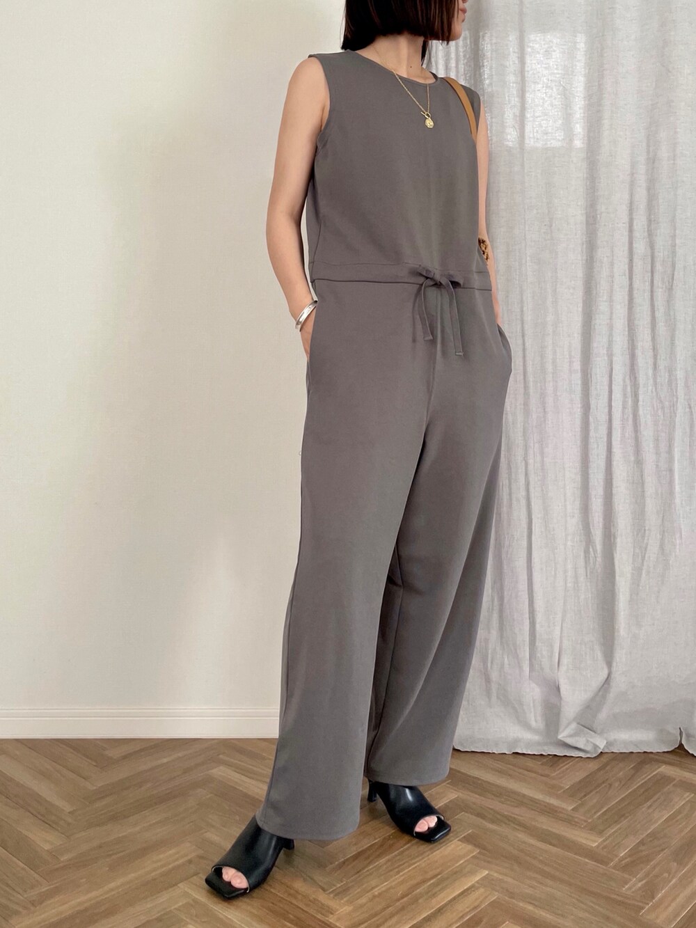 ベージュ系のトートバッグ、ブラック系のサロペット/オーバーオール、ブラック系のカーディガン/ボレロを着用したレディースの夏コーディネートの2枚目の写真