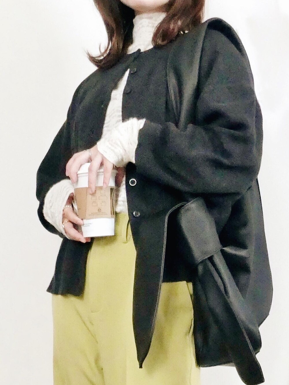 グリーン系のスラックス、ホワイト系のTシャツ/カットソー、ブラック系のカーディガン/ボレロを着用したレディースの冬コーディネートの3枚目の写真