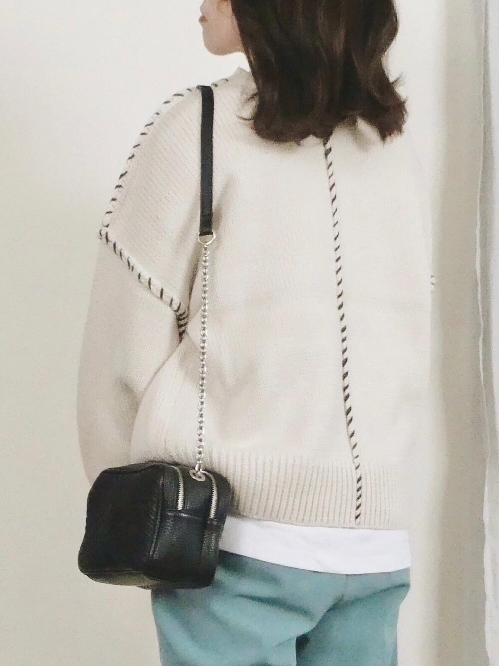 ホワイト系のニット/セーター、ブルー系のその他パンツを着用したレディースの冬コーディネートの3枚目の写真