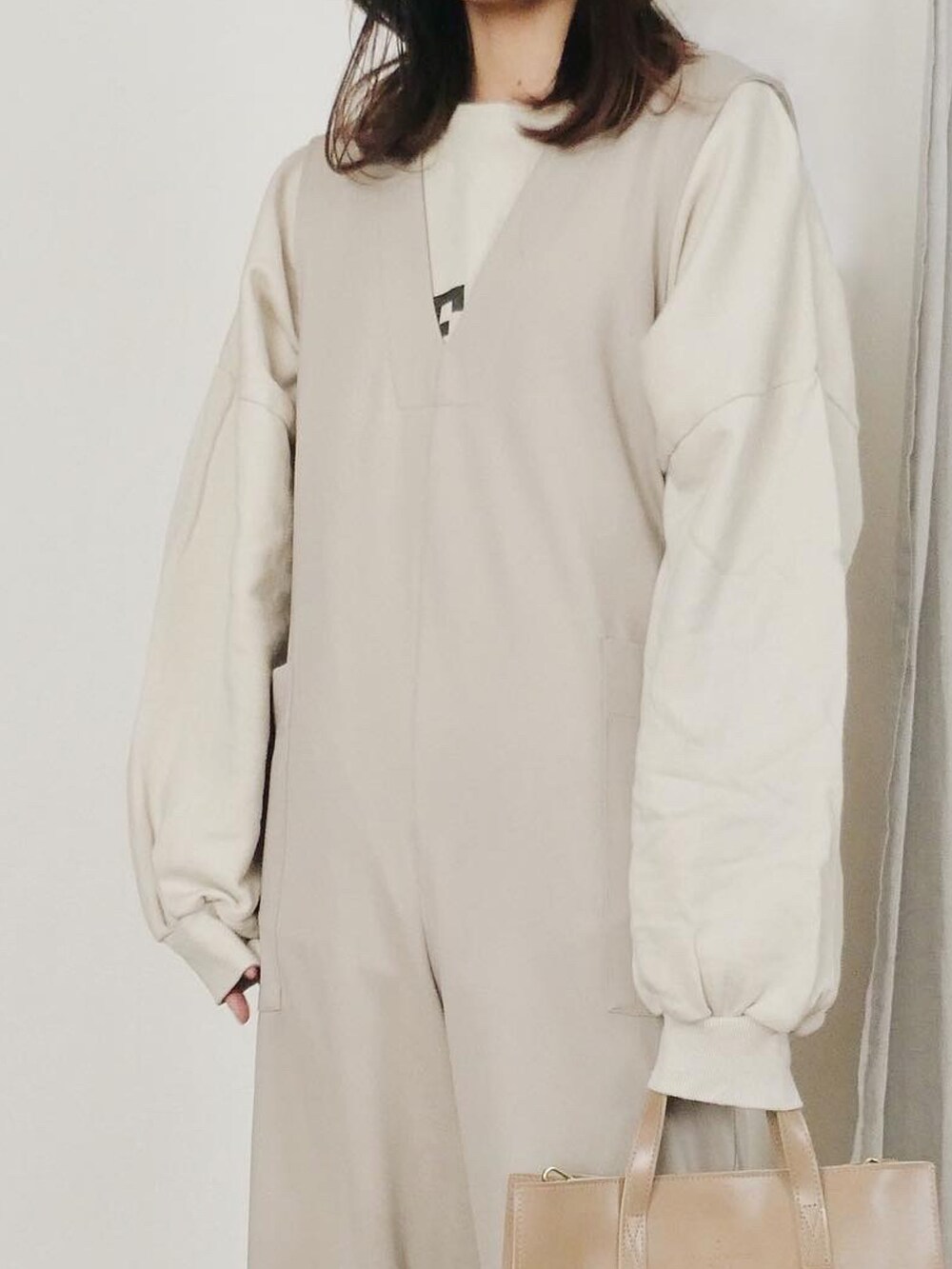 ベージュ系のつなぎ/オールインワン、ホワイト系のスウェット、ベージュ系のスリッポンを着用したレディースの冬コーディネートの3枚目の写真