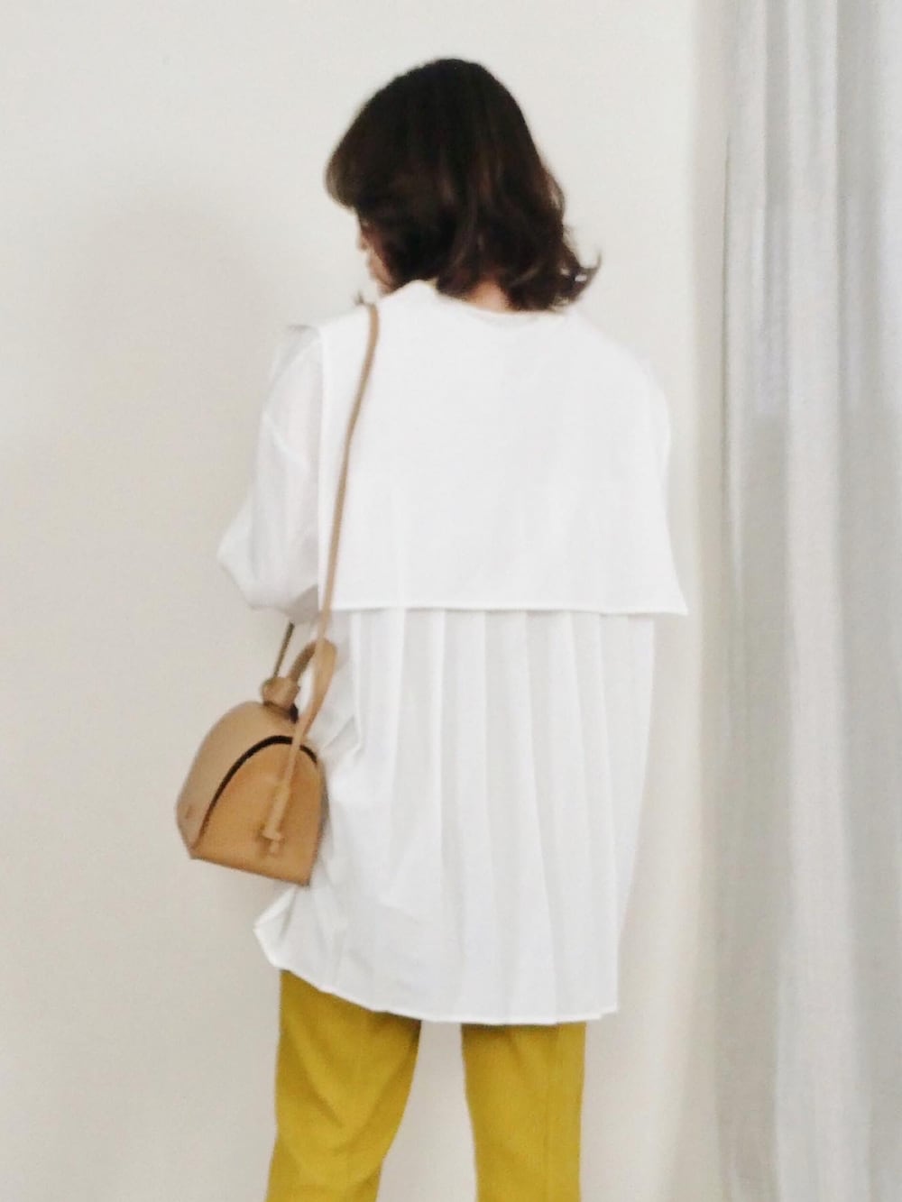 ホワイト系のシャツ/ブラウス、ブラウン系のブルゾン、ベージュ系のショルダーバッグを着用したレディースの冬コーディネートの3枚目の写真