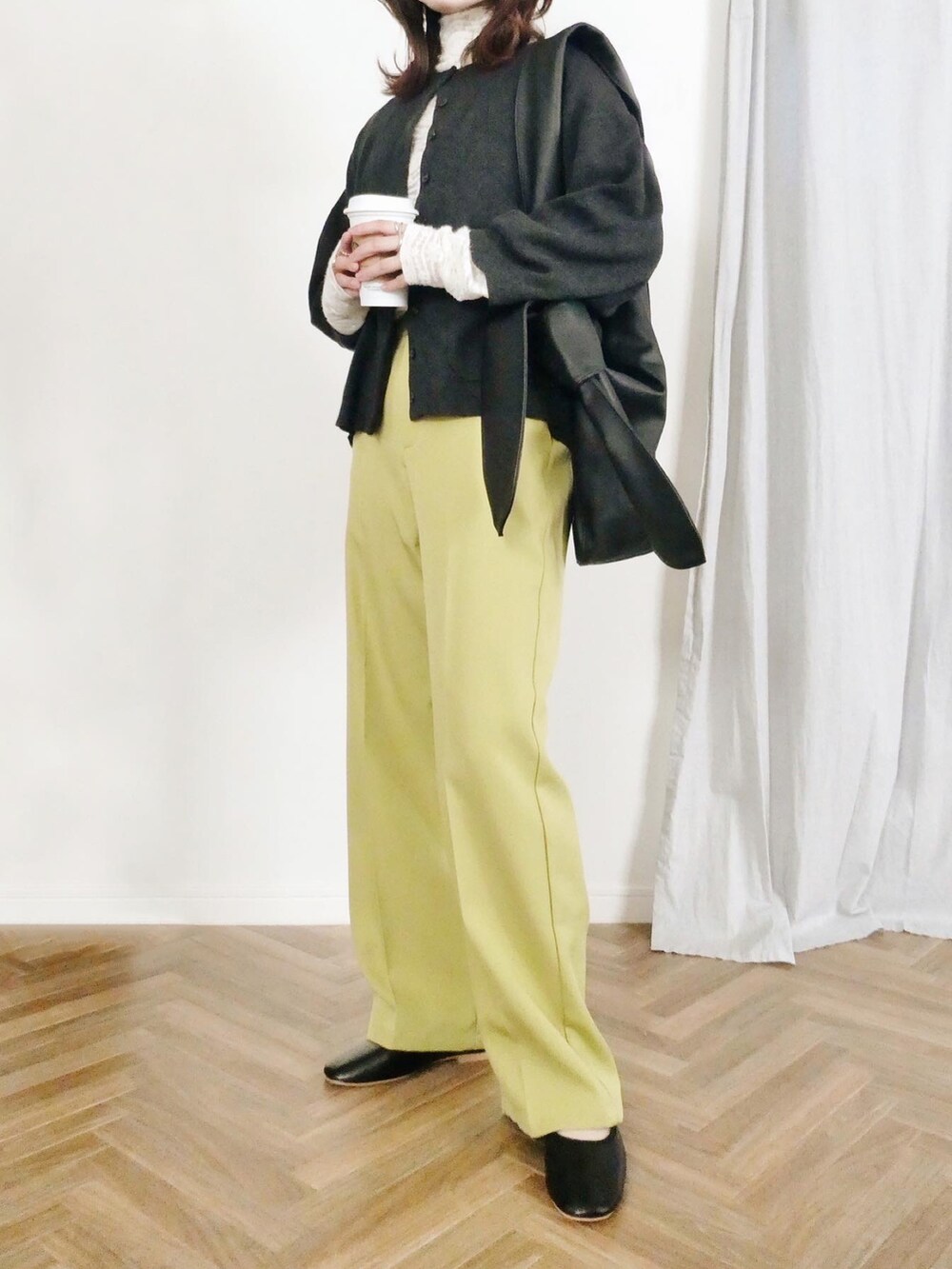 グリーン系のスラックス、ホワイト系のTシャツ/カットソー、ブラック系のカーディガン/ボレロを着用したレディースの冬コーディネートの2枚目の写真