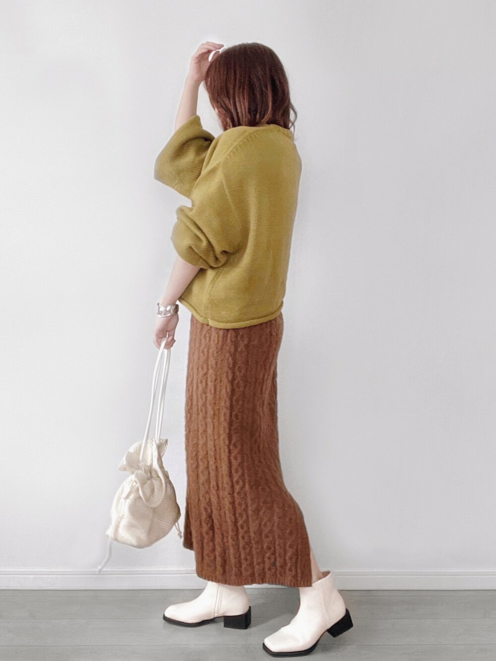 グリーン系のニット/セーター、ホワイト系のショルダーバッグを着用したレディースの秋コーディネートの3枚目の写真