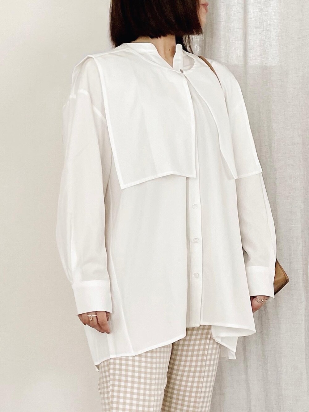 ホワイト系のシャツ/ブラウス、ベージュ系のショルダーバッグを着用したレディースの春コーディネートの3枚目の写真