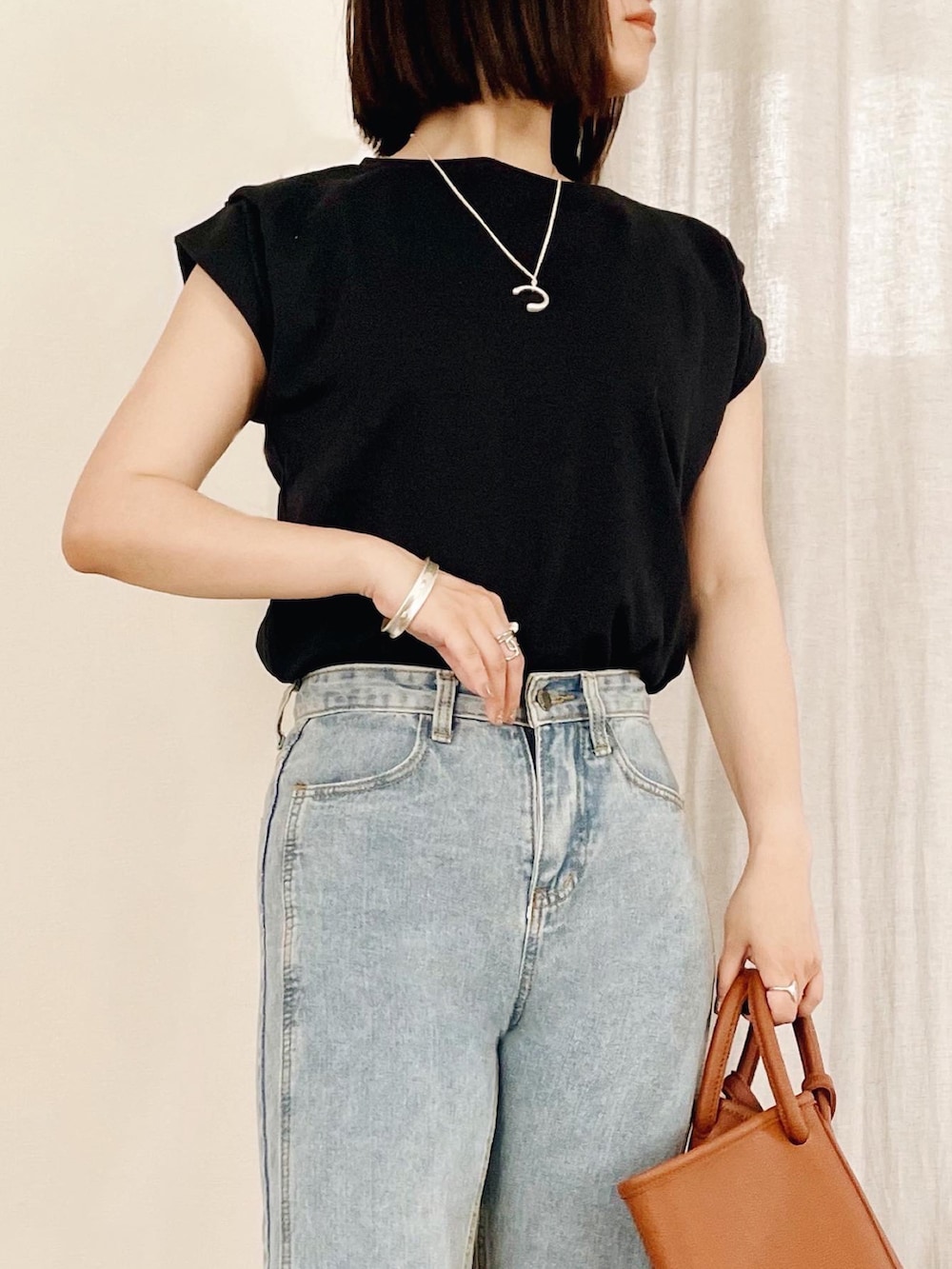 ブルー系のデニムパンツ、ブラック系のTシャツ/カットソーを着用したレディースの夏コーディネートの3枚目の写真