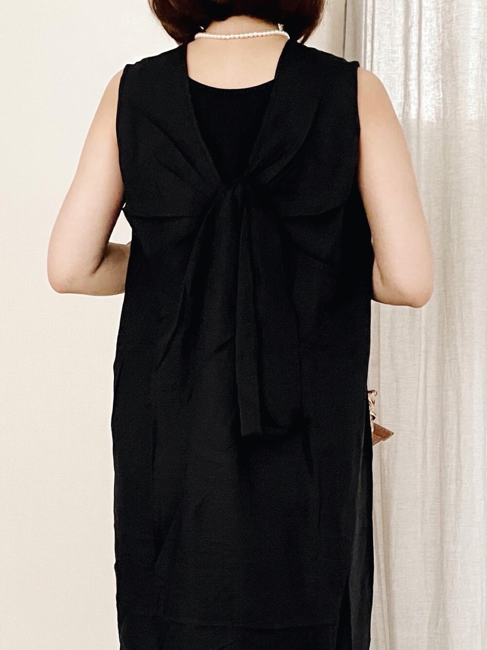 ブラック系のドレス、ブラウン系のかごバッグを着用したレディースの夏コーディネートの3枚目の写真