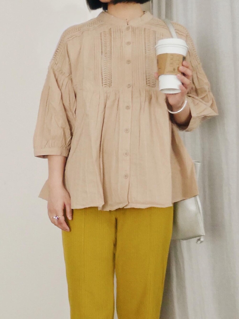 ベージュ系のシャツ/ブラウス、イエロー系のその他パンツ、シルバー系のショルダーバッグを着用したレディースの春コーディネートの3枚目の写真