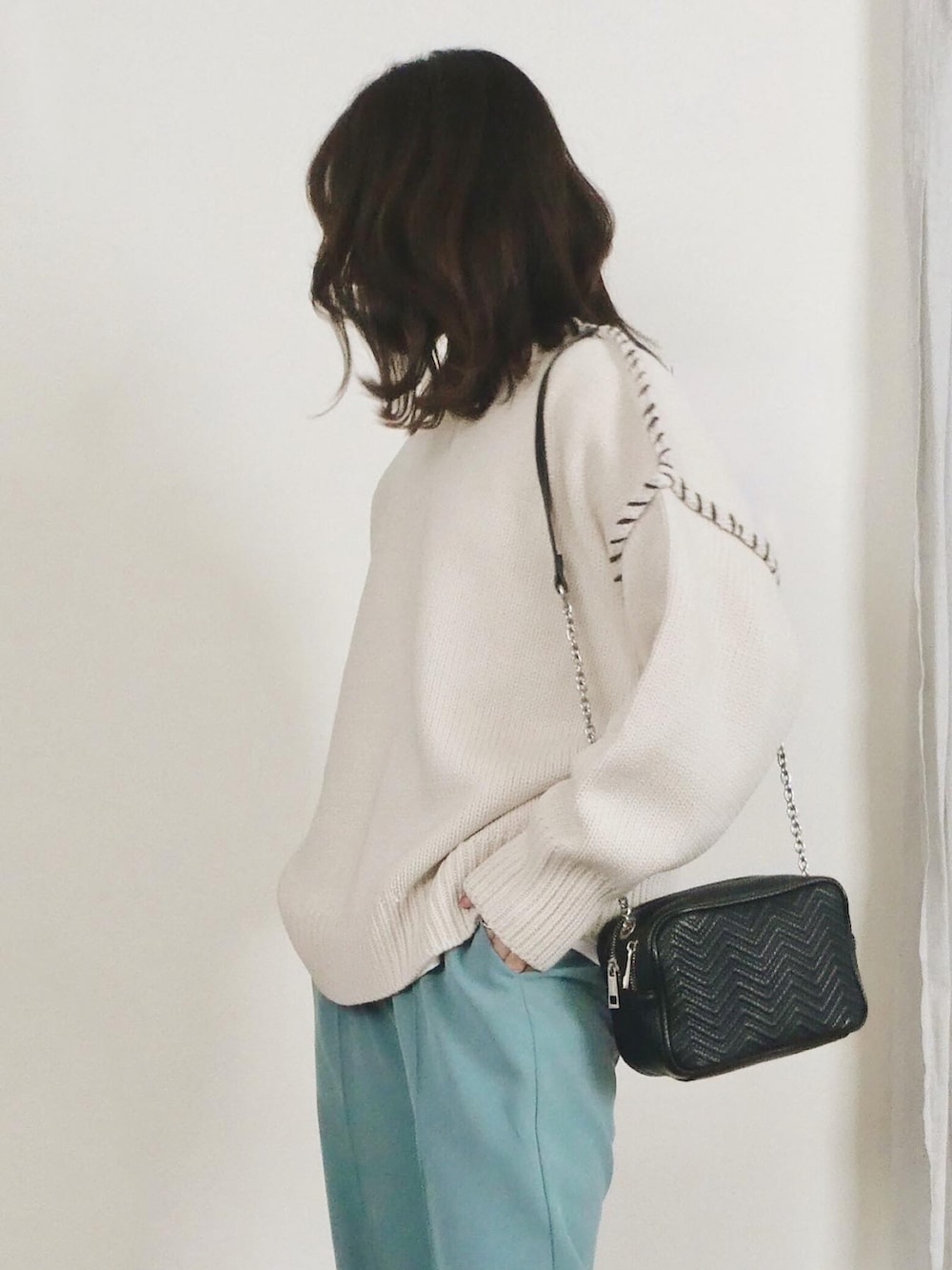 ホワイト系のニット/セーター、ブルー系のその他パンツを着用したレディースの冬コーディネートの2枚目の写真