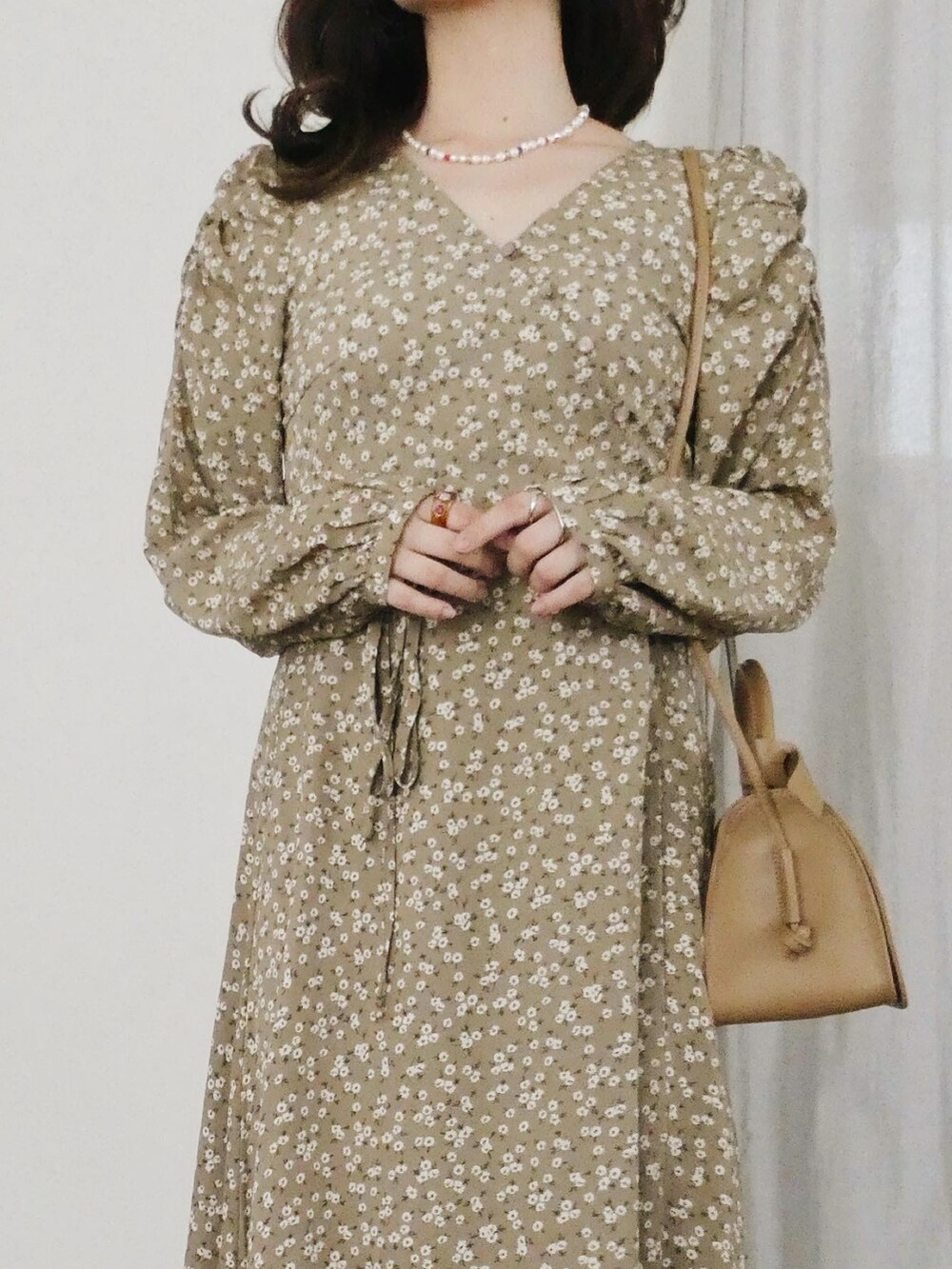 ブラック系のスニーカー、ベージュ系のショルダーバッグ、ベージュ系のワンピースを着用したレディースの春コーディネートの3枚目の写真