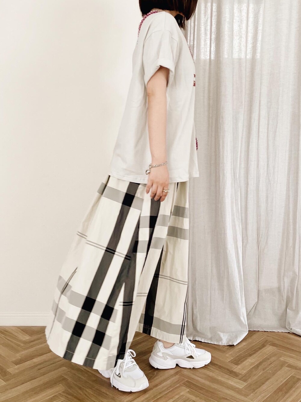 ホワイト系のスカート、ホワイト系のスニーカーを着用したレディースの夏コーディネートの2枚目の写真