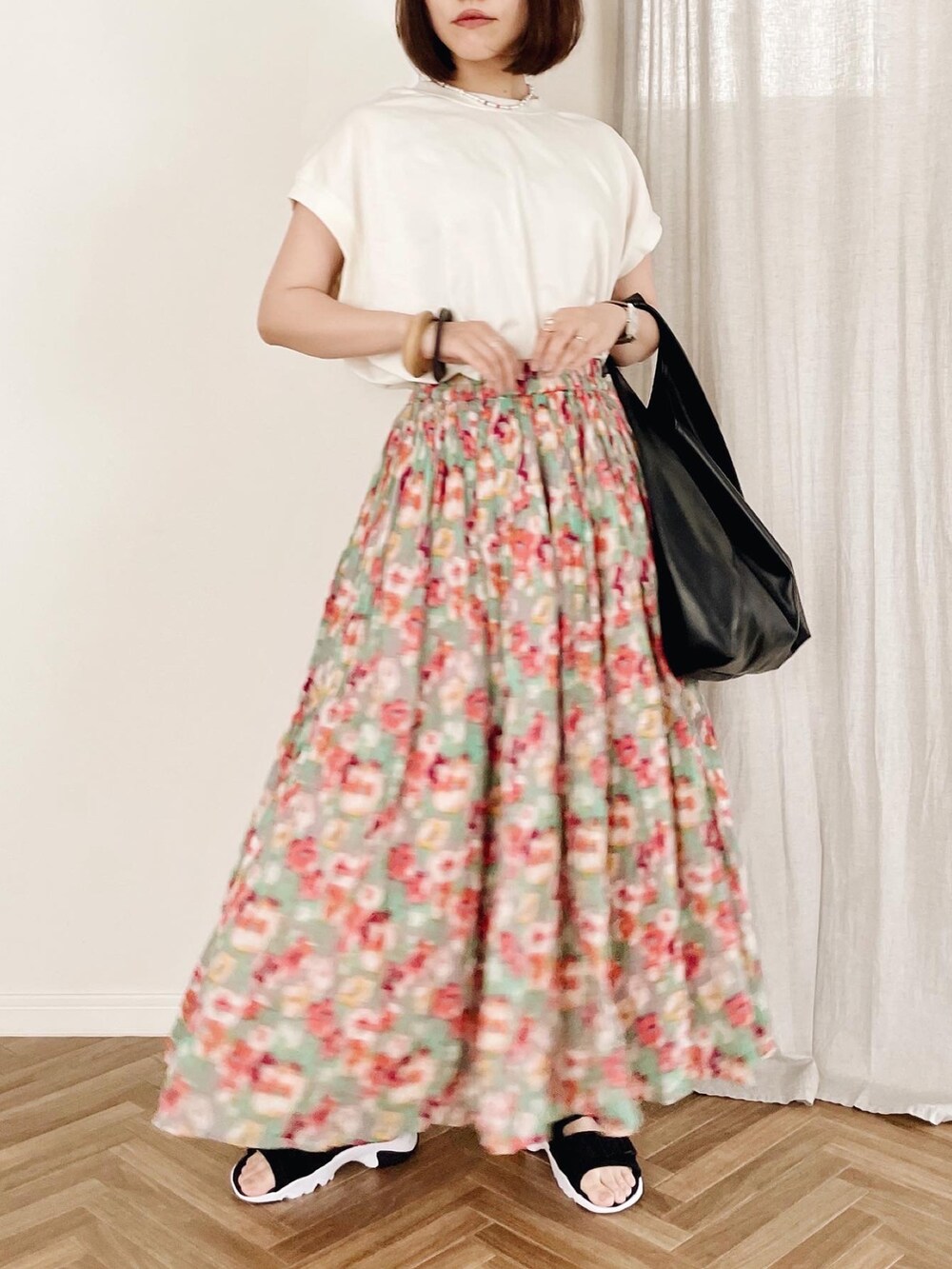 ホワイト系のTシャツ/カットソー、レッド系のスカート、ブラック系のトートバッグを着用したレディースの夏コーディネートの3枚目の写真