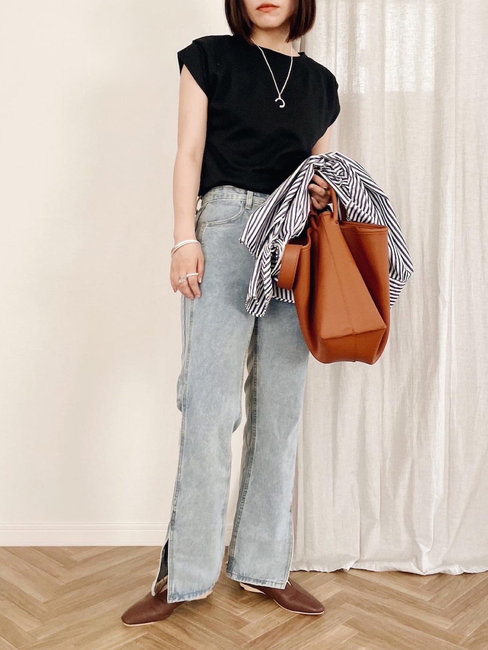 ブルー系のデニムパンツ、ブラック系のTシャツ/カットソーを着用したレディースの夏コーディネートの2枚目の写真