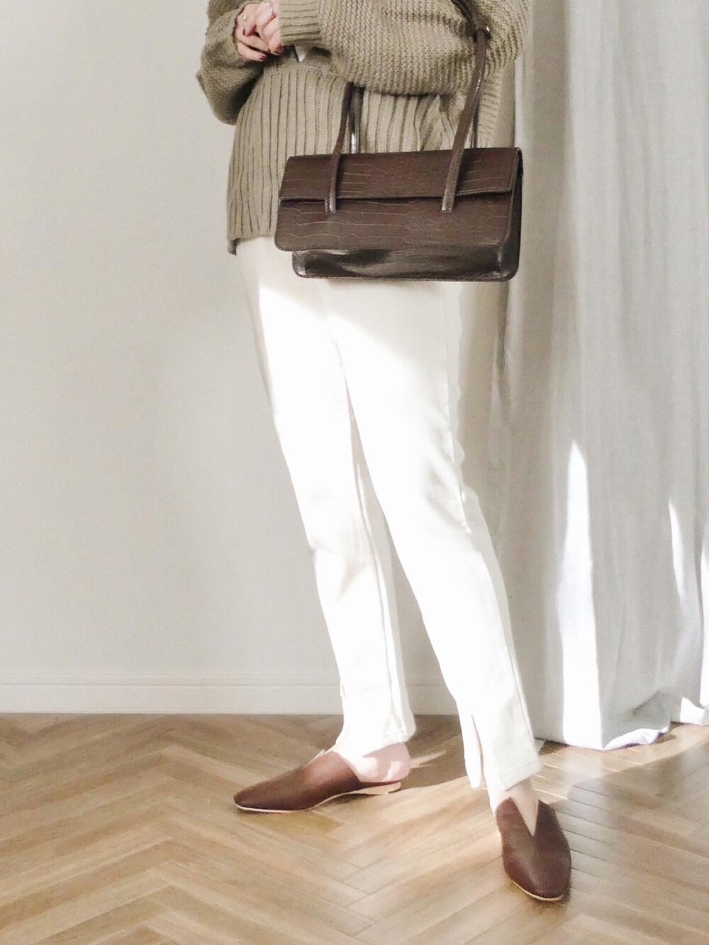 ホワイト系のスウェットパンツ、ブラウン系のショルダーバッグ、ベージュ系のニット/セーターを着用したレディースの冬コーディネートの2枚目の写真