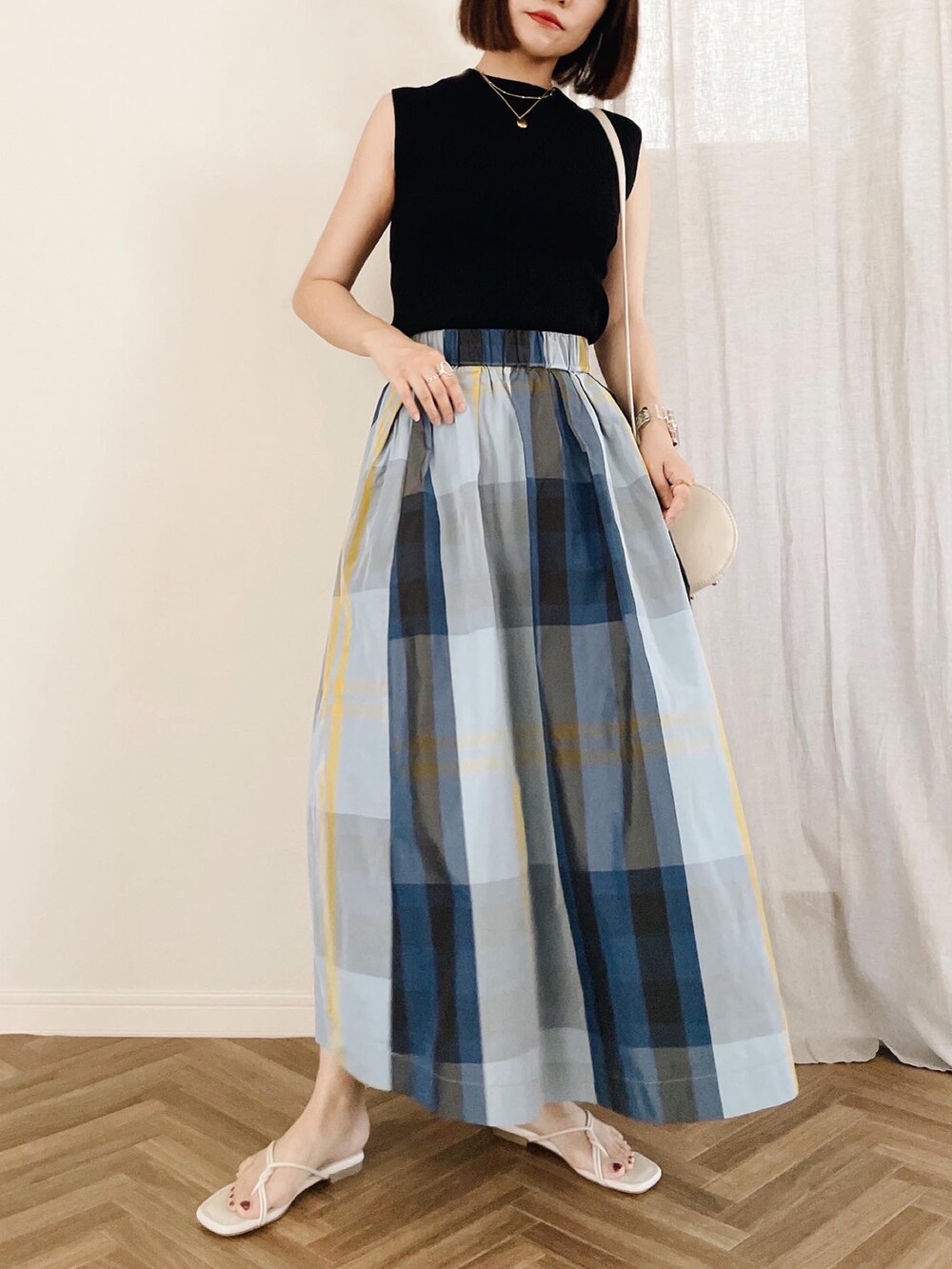 ブラック系のニット/セーター、ホワイト系のショルダーバッグ、ホワイト系のサンダルを着用したレディースの夏コーディネートの3枚目の写真