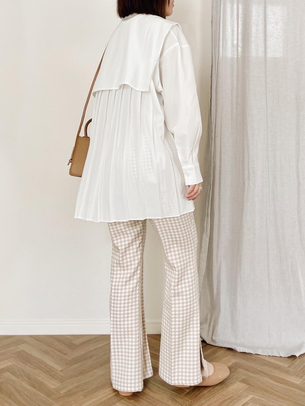 ホワイト系のシャツ/ブラウス、ベージュ系のショルダーバッグを着用したレディースの春コーディネートの2枚目の写真