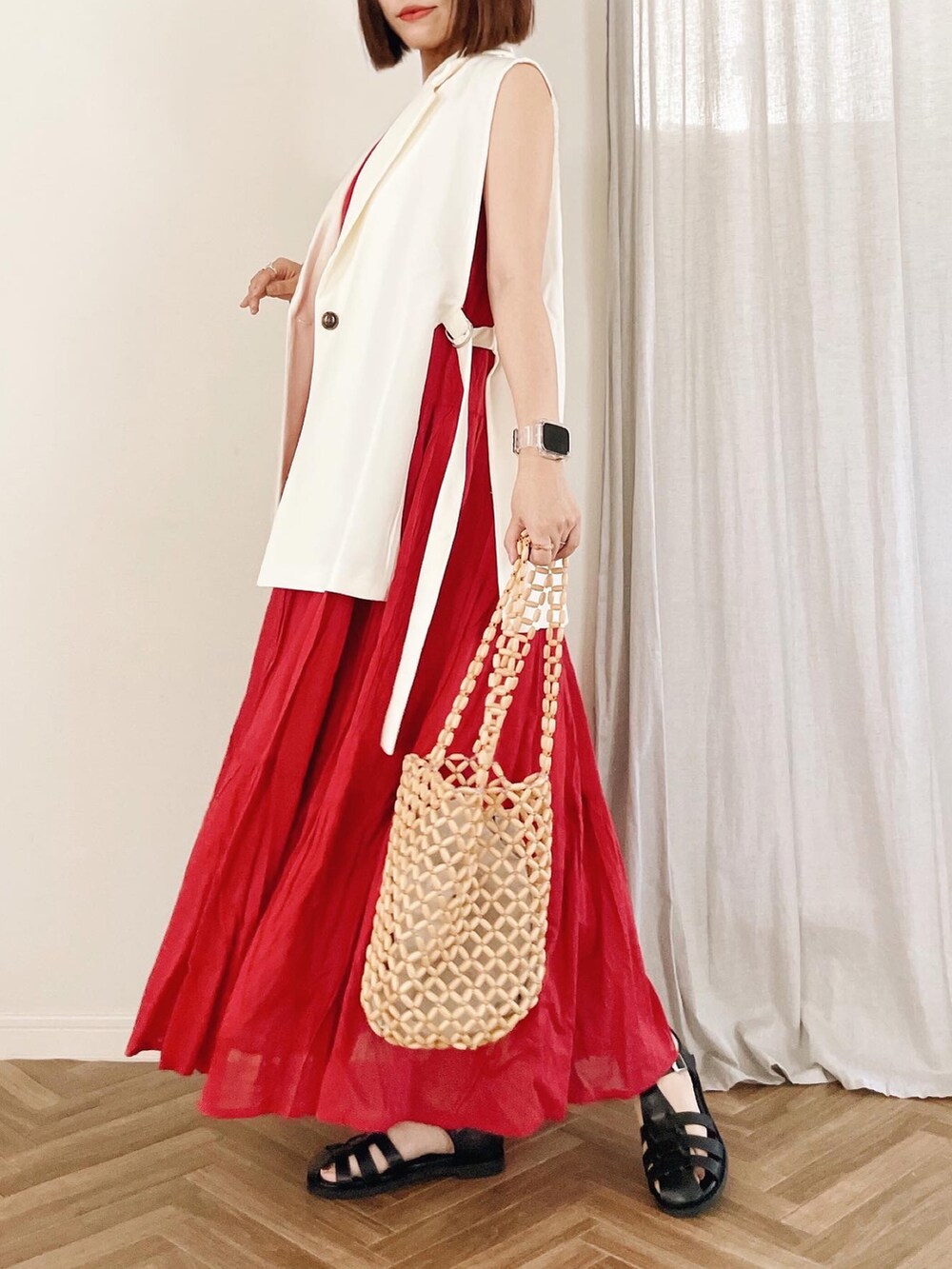 ホワイト系のベスト、ベージュ系のトートバッグ、レッド系のワンピースを着用したレディースの夏コーディネートの2枚目の写真