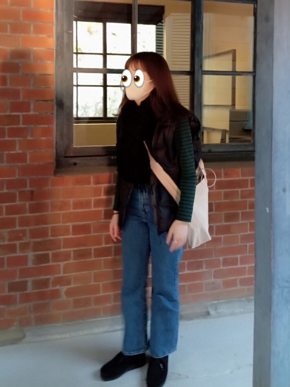 ブルー系のデニムパンツ、ブラック系のダウンベスト、グリーン系のTシャツ/カットソーを着用したレディースの春コーディネートの3枚目の写真