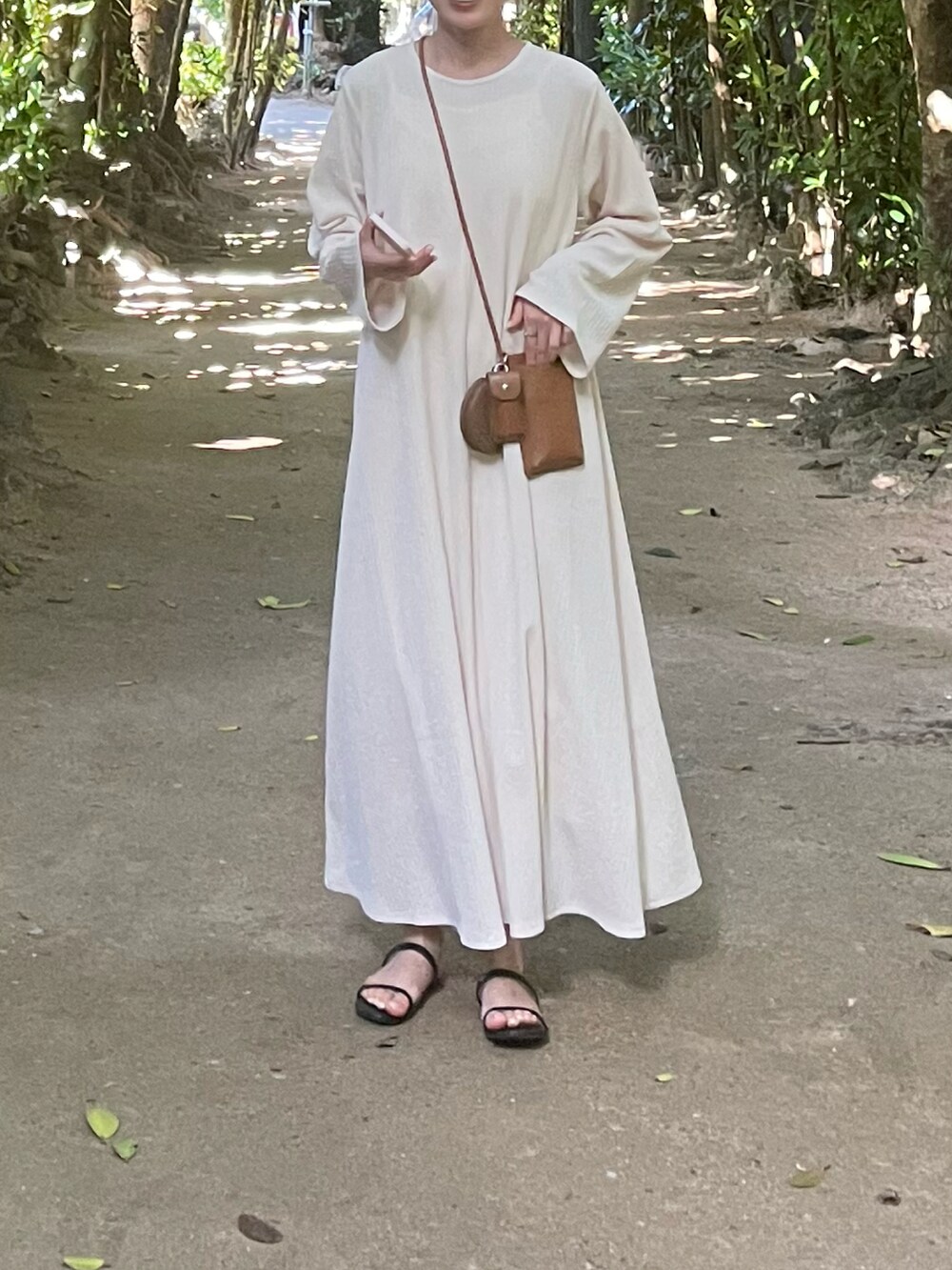 ベージュ系のワンピース、ブラウン系のショルダーバッグ、ブラック系のサンダルを着用したレディースの秋コーディネートの2枚目の写真