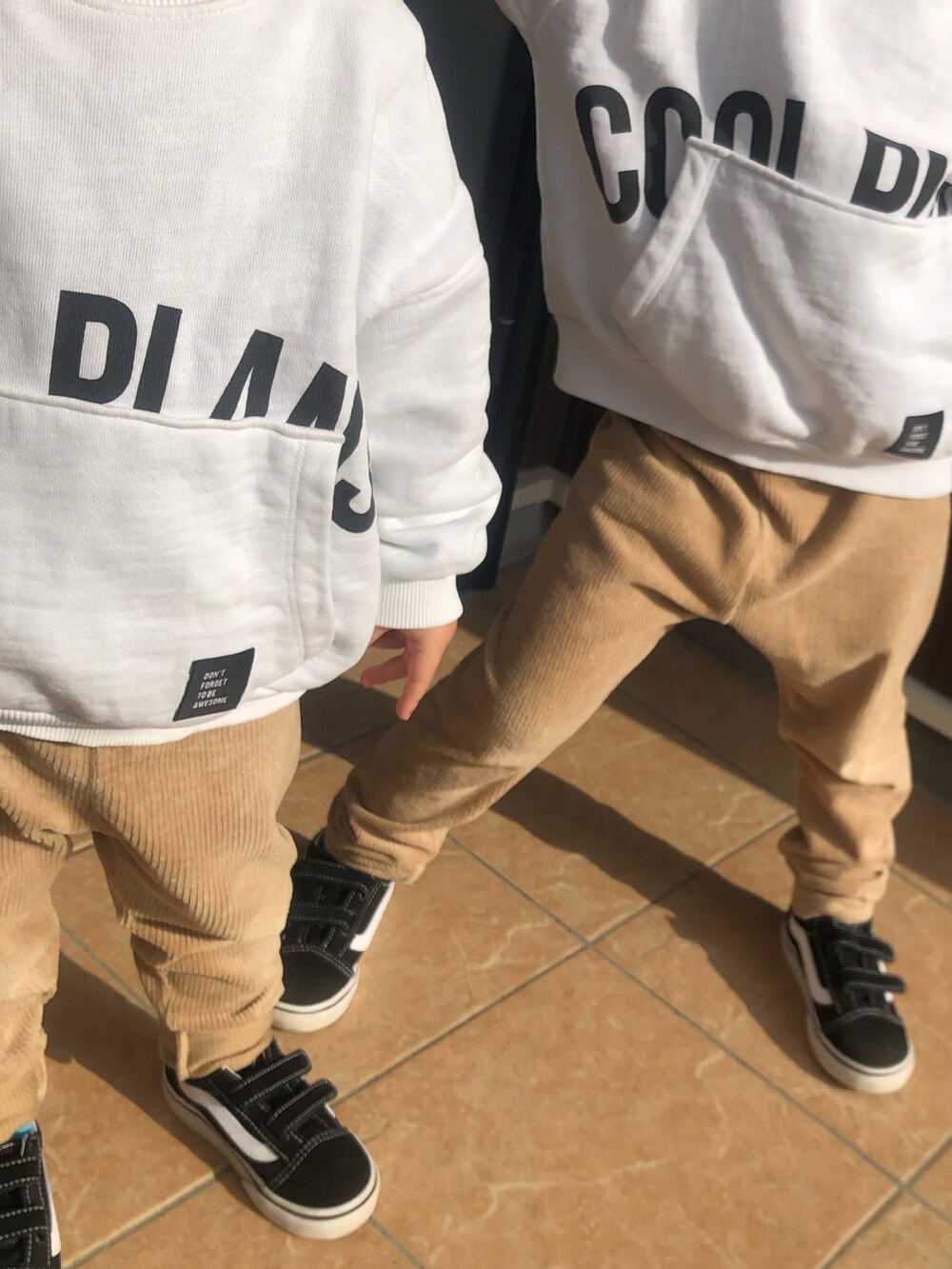 ベージュ系のその他パンツ、ブラック系のスニーカー、ホワイト系のTシャツ/カットソーを着用したレディースの秋コーディネートの2枚目の写真