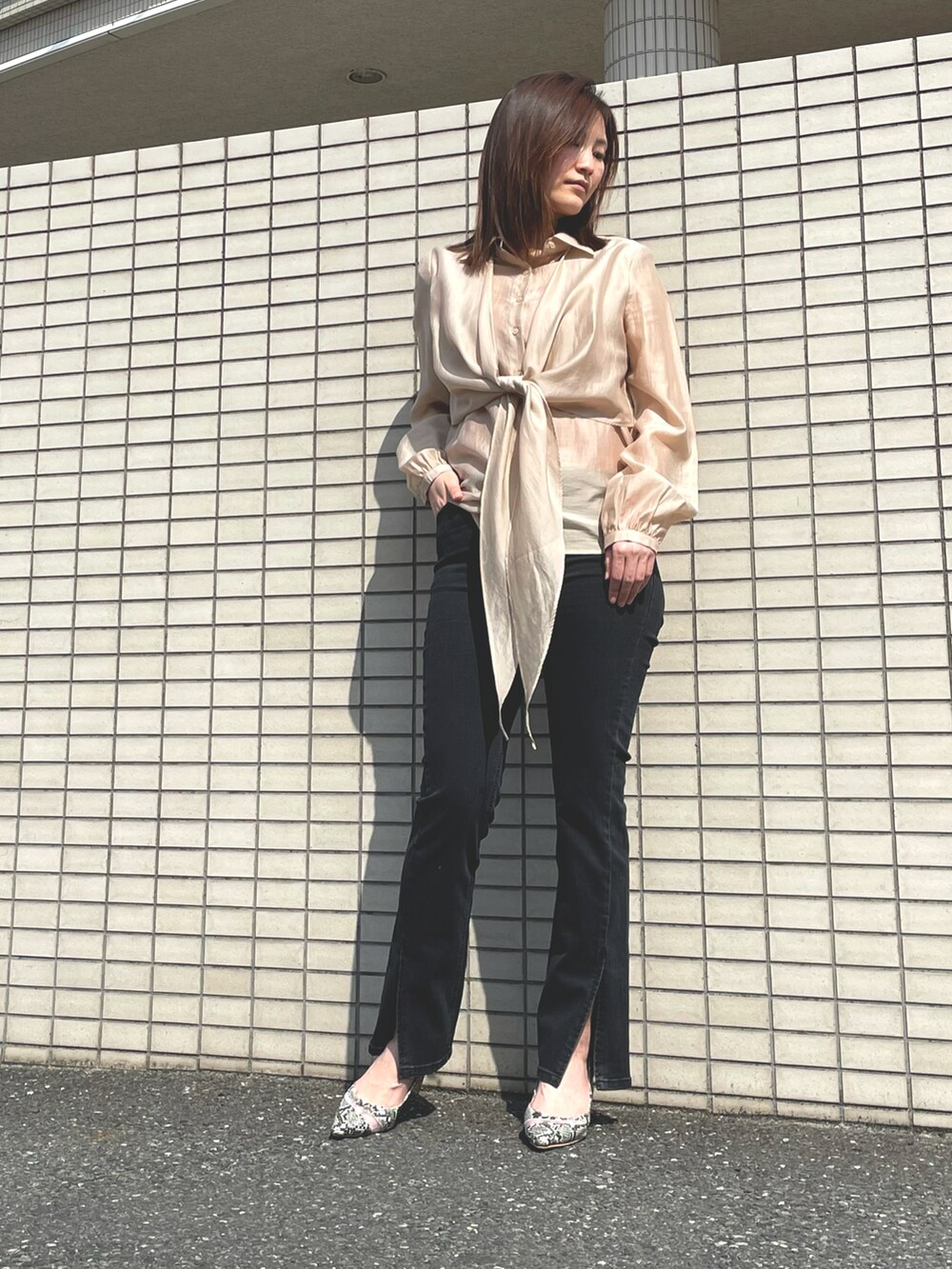 ベージュ系のシャツ/ブラウス、ブラック系のデニムパンツを着用したレディースの春コーディネートの2枚目の写真