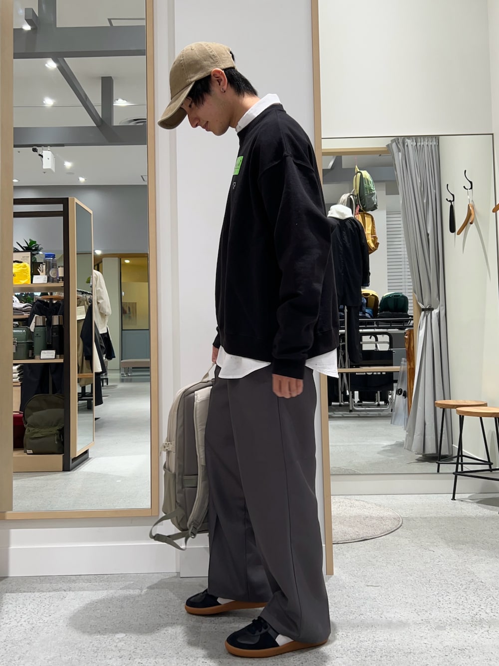 ベージュ系のバックパック/リュック、ブラック系のスウェット、ホワイト系のシャツ/ブラウスを着用したメンズの春コーディネートの2枚目の写真