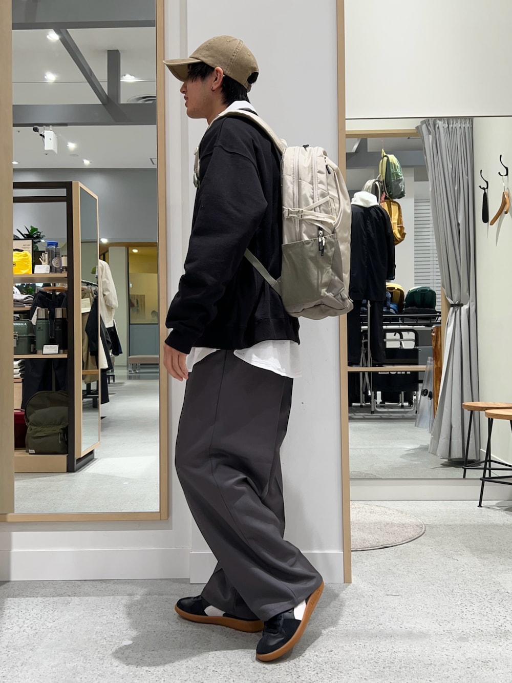 ベージュ系のバックパック/リュック、ブラック系のスウェット、ホワイト系のシャツ/ブラウスを着用したメンズの春コーディネートの3枚目の写真