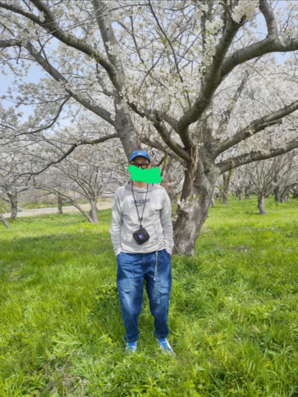 ホワイト系のスニーカー、グレー系のパーカー、ブルー系のデニムパンツを着用したメンズの春コーディネートの2枚目の写真