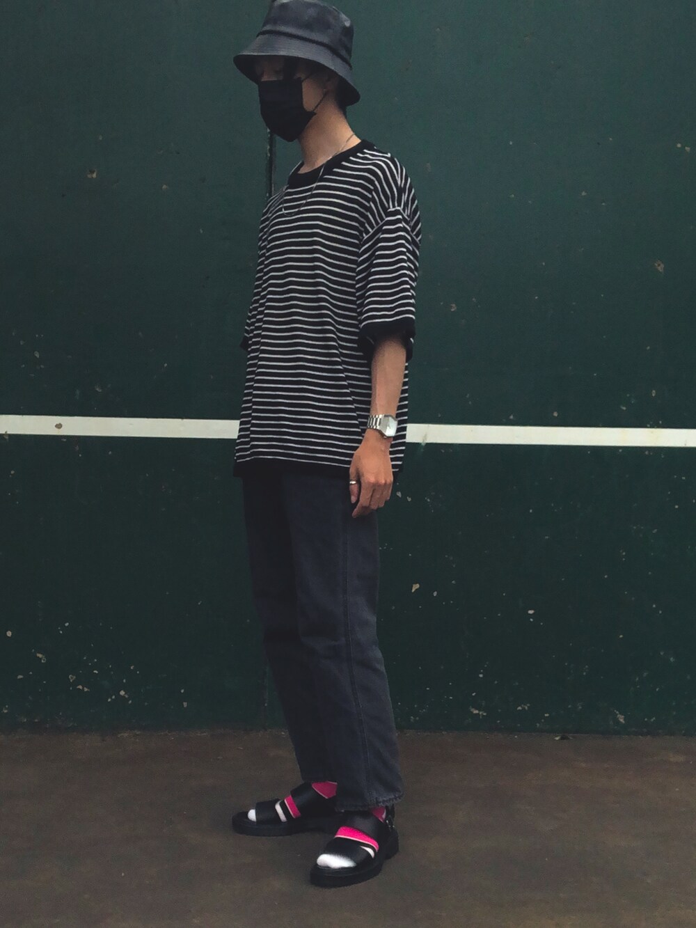 グレー系のデニムパンツ、ブラック系のニット/セーター、ブラック系のハットを着用したメンズの春コーディネートの2枚目の写真