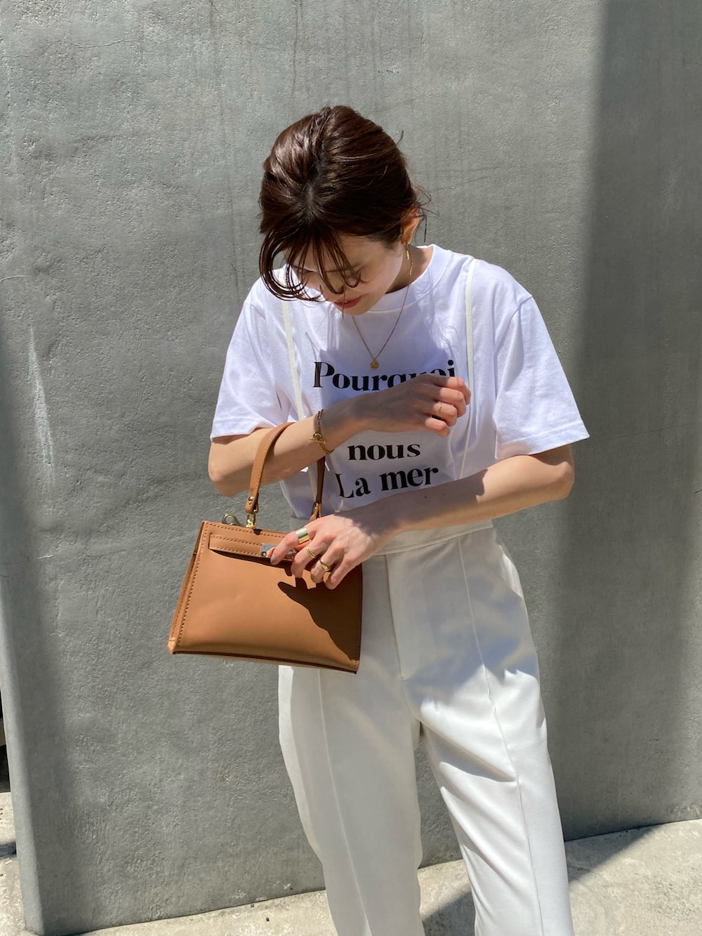ホワイト系のその他パンツ、ブラウン系のTシャツ/カットソー、ブラウン系のバッグを着用したレディースの夏コーディネートの2枚目の写真