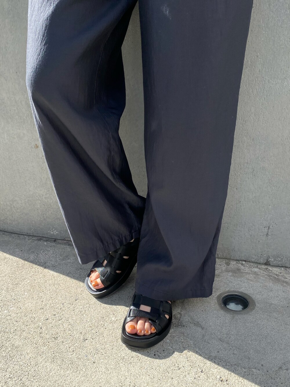 グレー系のその他パンツ、ブラック系のサンダルを着用したレディースの春コーディネートの2枚目の写真