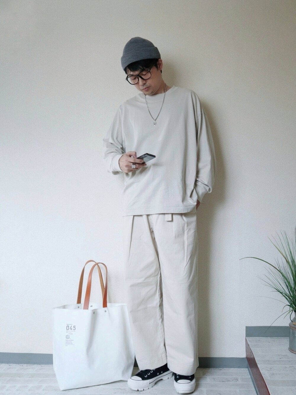 ホワイト系のその他パンツ、ブラック系のスニーカー、ホワイト系のトートバッグを着用したメンズの秋コーディネートの3枚目の写真
