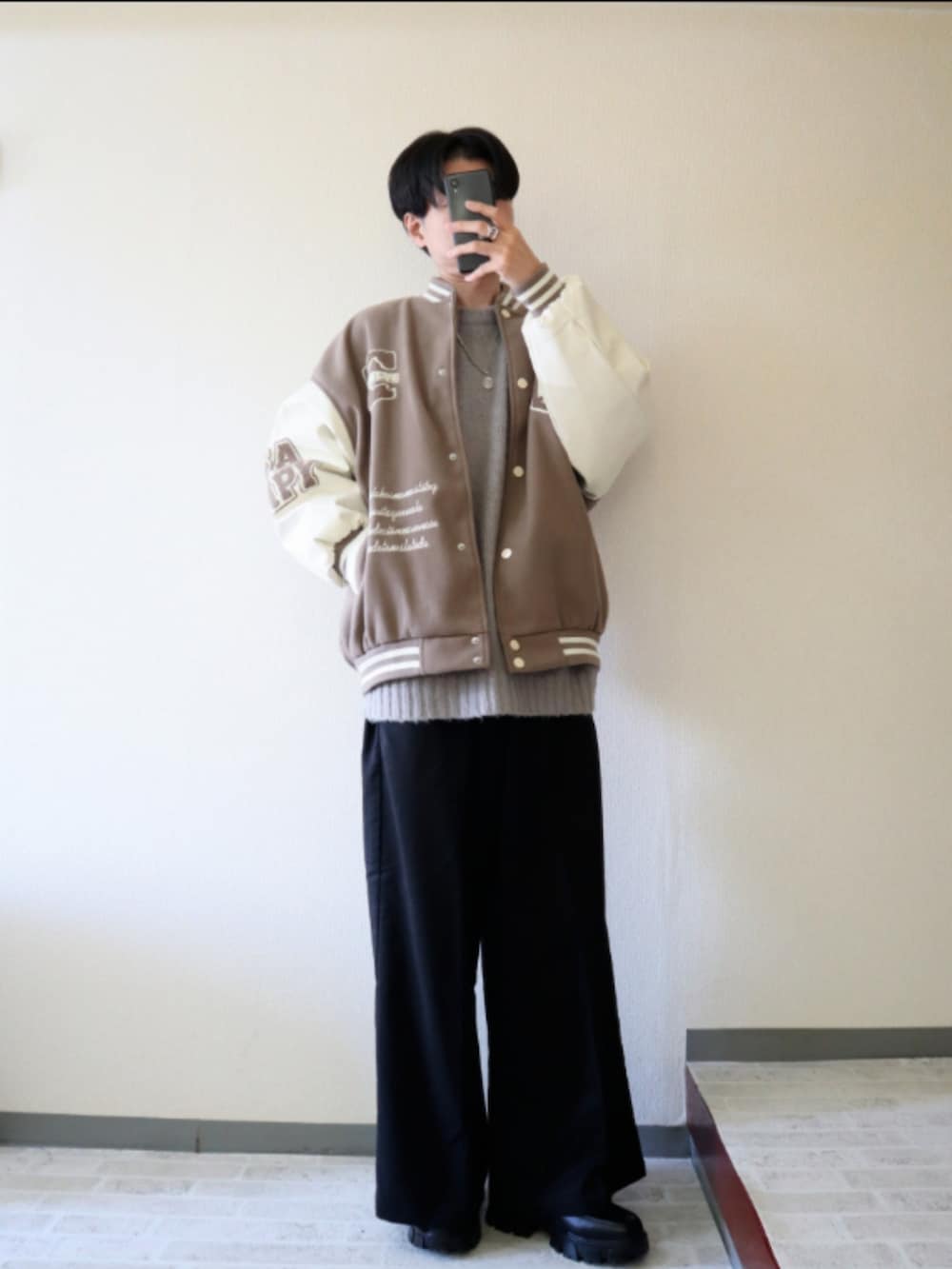 ベージュ系のスタジャン、ブラック系のその他パンツ、グレー系のニット/セーターを着用したメンズの春コーディネートの2枚目の写真