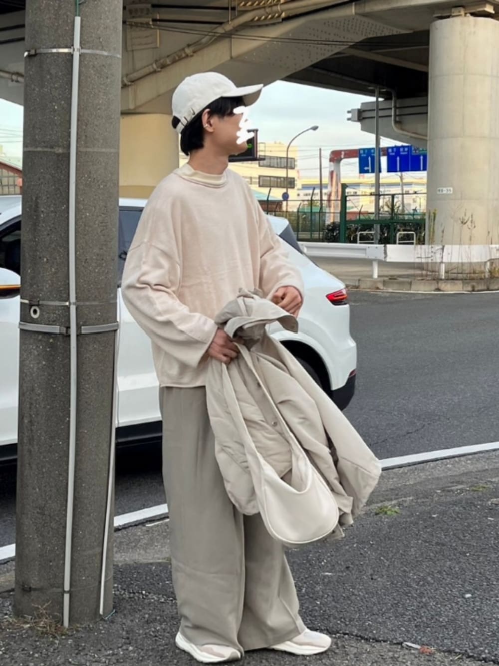 ホワイト系のショルダーバッグ、ホワイト系のニット/セーター、ベージュ系のスラックスを着用したメンズの冬コーディネートの2枚目の写真